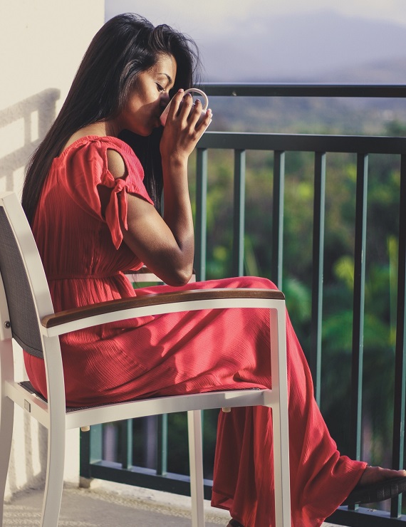 woman in a pink dress drinking detox tea